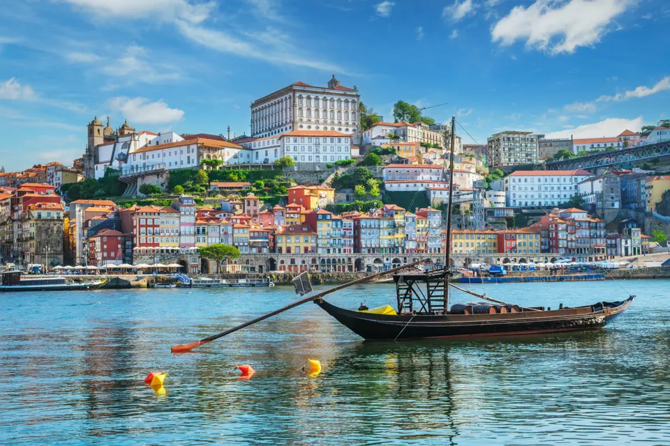 A rabelo boat on the Douro in front of Porto's coloured Ribeira houses